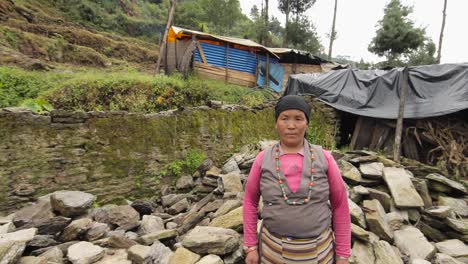 A-Nepalese-woman-stands-in-front-of-a-makeshift-tent-home-after-becoming-homeless-during-the-devastating-earthquake-there