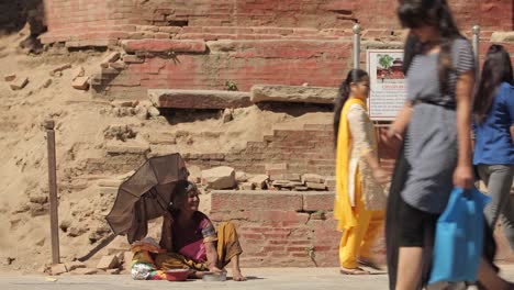 People-walk-past-and-ignore-a-homeless-beggar-on-the-streets-of-India-or-Nepal