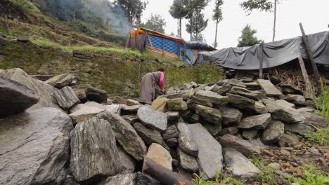 Eine-Nepalesische-Frau-Stapelt-Steine-Vor-Einem-Provisorischen-Zelthaus,-Nachdem-Sie-Während-Des-Verheerenden-Erdbebens-Dort-Obdachlos-Geworden-Ist