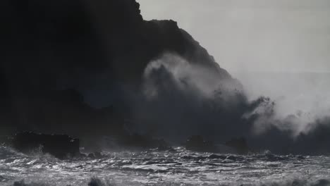 Huge-ocean-waves-roll-and-crash-into-a-rocky-shore-in-slow-motion