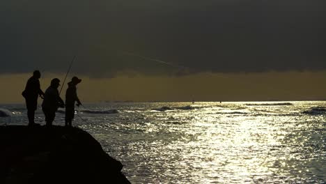 Three-Fishermen-cast-during-sunset-at-Ala-Moana-Beach-Park-in-Honolulu-Hawaii