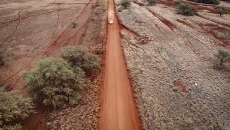 Aerial-over-two-white-cars-chasing-or-following-each-other-on-a-dirt-road-in-Molokai-Hawaii-from-Maunaloa-to-Hale-o-Lono