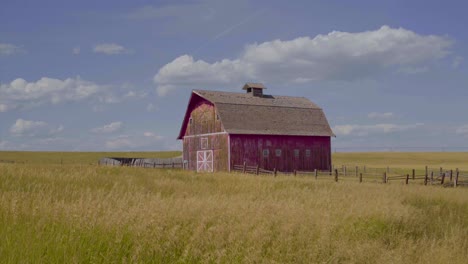 A-red-barn-surrounded-by-golden-grass-in-Montanas-Big-Sky-Country