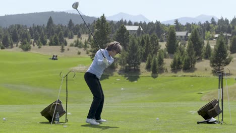 A-female-golfer-swings-a-driver-on-the-Rock-Creek-Cattle-Company-golf-course-in-Montana
