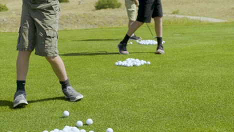 Drei-Junge-Golfer-Schlagen-Einen-Eimer-Mit-Bällen-Auf-Der-Driving-Range-Von-Rock-Creek-Cattle-Co