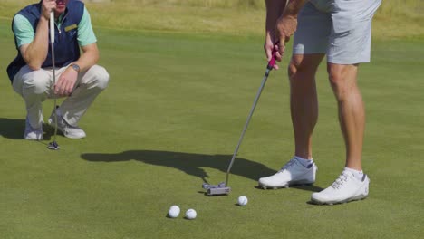 Close-up-shot-of-a-golfer-practicing-his-putting-putting-technique-on-a-golf-green
