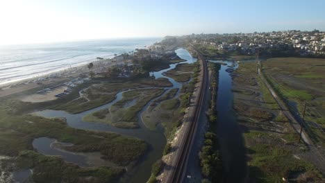 High-aerial-over-an-Amtrak-train-traveling-beside-the-Pacific-ocean-near-San-Diego