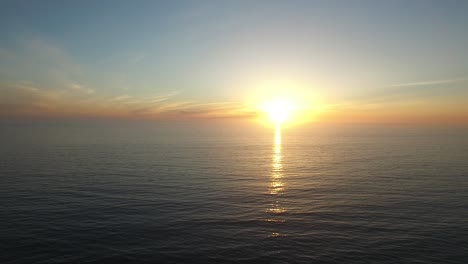 A-beautiful-aerial-above-a-golden-sunset-over-a-generic-ocean-coast