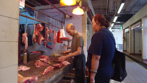 A-meat-seller-in-Hong-Kong-cuts-meat-with-a-knife-for-a-customer