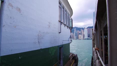 Establishing-shot-from-the-ferry-boat-reveals-Hong-Kong-harbor-and-skyline-with-clouds