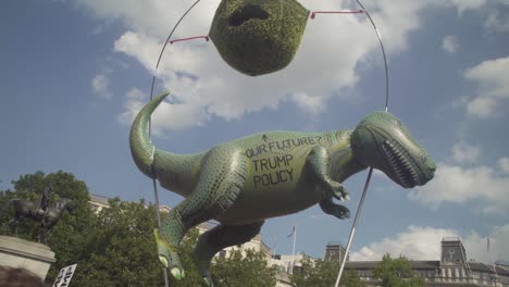 A-Huge-Green-Dinosaur-Doll-Above-Huge-Crowds-Of-Protesters-Gathering-On-The-Streets-Of-London-To-Protest-The-Visit-Of-US-President-Donald-Trump