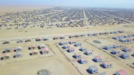 Aerial-over-a-strange-abandoned-town-of-empty-lonely-suburban-tract-houses-in-the-desert-of-Namibia-Africa-1