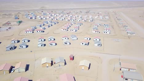 Aerial-over-a-strange-abandoned-town-of-empty-lonely-suburban-tract-houses-in-the-desert-of-Namibia-Africa-7