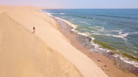 Aerial-over-a-model-released-woman-walking-on-magnificent-sand-dunes-on-the-Skeleton-Coast-Namibia-1