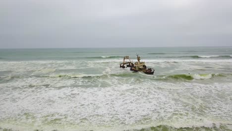 Amazing-aerial-over-a-4WD-safari-vehicle-on-a-beach-near-a-shipwreck-along-the-Skeleton-Coast-of-Namibia-Africa