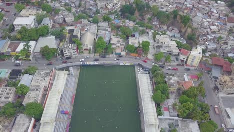 Antenne-über-Den-Slums-Favela-Und-Elendsvierteln-Im-Stadtteil-Cite-Soleil-Von-Port-Au-Prince-Haiti-Mit-Fußballstadion-Vordergrund