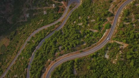 Vista-Aérea-of-cars-navigating-on-a-very-narrow-winding-montaña-road-with-many-switchbacks-and-hairpin-turns