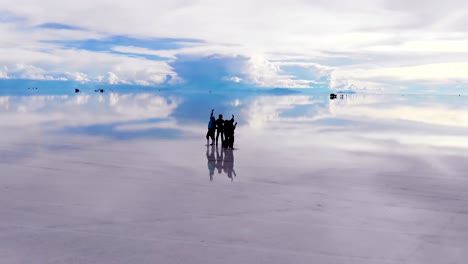 Aerial-of-people-and-jeeps-on-the-Uyuni-salt-flats-lake-with-perfect-reflections-in-Bolivia-1