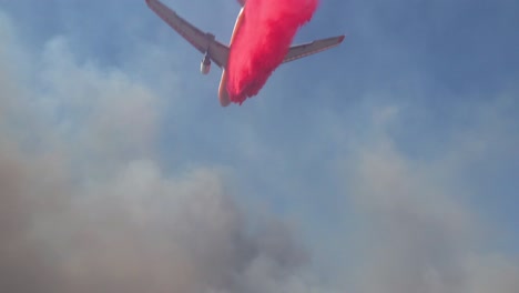 Ein-Lufttankflugzeug-Lässt-Einen-Rosa-Phoschek-Feuerschutz-über-Einem-Lauffeuer-Fallen,-Das-In-Den-Hügeln-über-Südkalifornien-Brennt