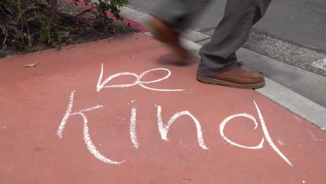 A-Sign-On-A-Sidewalk-Says-""Be-Kind""-During-The-Coronavirus-Covid19-Pandemic-Epidemic-Outbreak