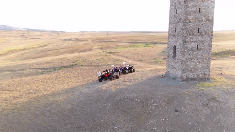 Aerial-Over-Atsvs-And-Riders-Parked-Near-A-Stone-Monument-In-The-Republic-Of-Georgia