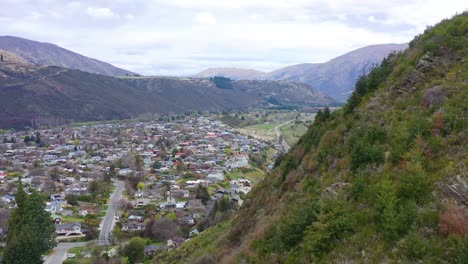 Aerial-Over-A-Valley-In-New-Zealand-With-A-Small-Town-Or-Village-Distance
