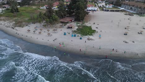 Aerial-Over-People-Playing-Soccer-Football-On-The-Beach-At-Bakau-Gambia-West-Africa
