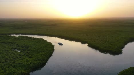 Schöne-Antenne-über-Einem-Kleinen-Boot,-Das-Sich-Entlang-Des-Gambia-Flusses-In-Westafrika-Durch-Mangrovenwälder-Und-Gewundene-Kurven-Bewegt-3