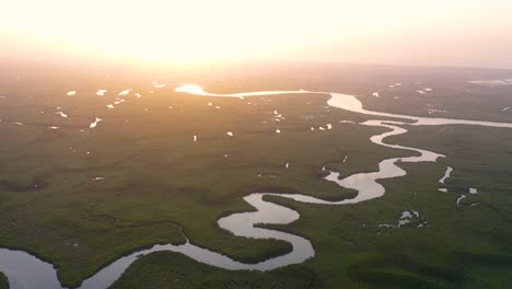Schöne-Antenne-über-Einem-Kleinen-Boot,-Das-Sich-Entlang-Des-Gambia-Flusses-In-Westafrika-Durch-Mangrovenwälder-Und-Gewundene-Kurven-Bewegt-5