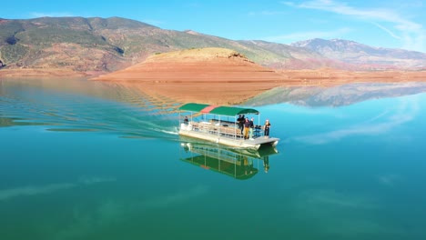 Pov-Aerial-Of-A-Man-Jumping-Off-A-Tourist-Boat-Soaked-In-Champagne-On-Lake-Bin-El-Ouidane-Morocco