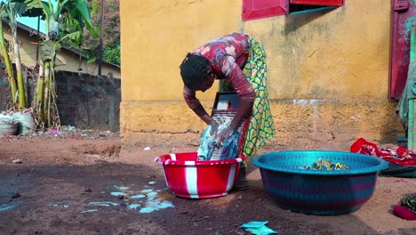 Eine-Frau-Wäscht-In-Westafrika-Wäsche-Von-Hand-Mit-Einem-Waschbrett