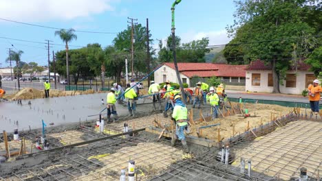 Construction-Workers-At-Construction-Site-With-Giant-Crane-Pouring-Concrete-Foundation-In-Ventura-California