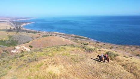 Hermosa-Antena-De-Jubilación-Pareja-De-Jubilados-A-Caballo-En-Un-Rancho-Con-Vistas-Al-Océano-Pacífico-En-Santa-Bárbara,-California-5