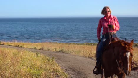 Una-Mujer-Vaquera-Galopa-En-Su-Caballo-A-Lo-Largo-Del-Océano-Pacífico-Cerca-De-Santa-Bárbara,-California