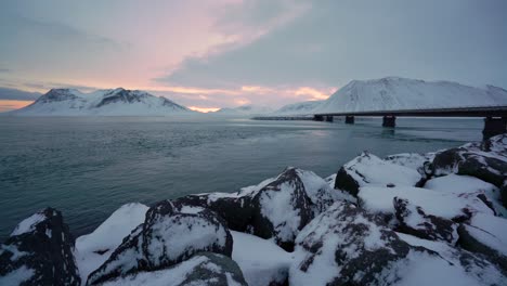 Snowy-banks-are-seen-on-the-Snaefellsne-Peninsula-in-Iceland-at-sunset-with-birds-swimming-in-the-water-1