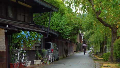 A-woman-walks-along-a-rainy-street-in-Sanmanchi-Suji-in-Takayama-Japan
