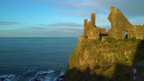 Dunluce-Castle-is-seen-perched-on-a-cliff-by-the-water-in-Antrim-County-Northern-Ireland