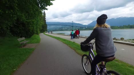 A-bikemounted-camera-captures-the-view-from-behind-as-a-woman-bicycles-along-the-Seawall-at-Stanley-Park-in-Vancouver