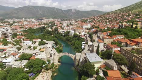Una-Vista-Aérea-Muestra-El-Puente-Mostar-Y-El-Río-Neretva-Sobre-El-Que-Pasa-En-Mostar,-Bosnia.