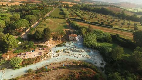 An-Aerial-View-Shows-Tourists-Enjoying-A-Lagoon-In-Saturnia-Italy