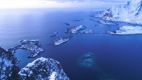 An-Aerial-View-Shows-Snowcovered-Mountains-And-Bridges-On-The-Lofoten-Islands-Norway