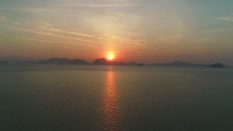 The-Sun-Sets-Over-A-Mountain-Range-And-Expansive-Body-Of-Water-In-Thailand-1