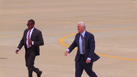Vice-President-Mike-Pence-Walks-Across-An-Airport-Tarmac-Waving-At-His-Followers