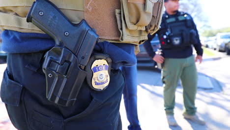 An-Ice-Officers-Badge-And-Gun-Are-Shown-In-Closeup-On-His-Belt