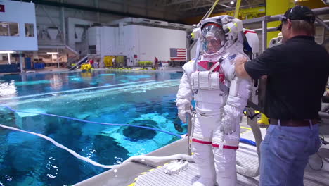 Ein-Astronaut-Wird-Zum-Training-In-Ein-Spezielles-Schwimmbecken-Getaucht,-Das-Gleichzeitig-Die-Arbeit-In-Der-Schwerelosigkeit-Simuliert