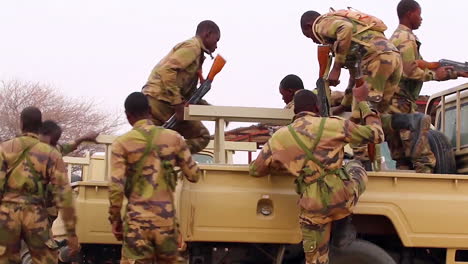 Nigerianische-Soldaten-Bauen-Ihre-Gewehre-Zusammen-Und-Besteigen-Lastwagen,-Um-Zur-Patrouille-Zu-Gehen