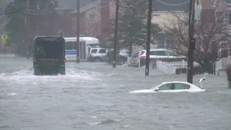 A-Truck-Drives-Members-Of-The-Massachusetts-National-Guard-Through-A-Flooded-Town