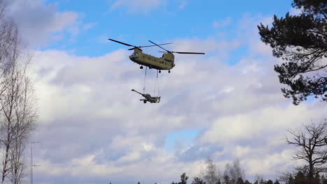 A-Us-Army-Helicopter-Transports-A-Piece-Of-Field-Artillery-As-Part-Of-Exercise-Dynamic-Front-In-Germany