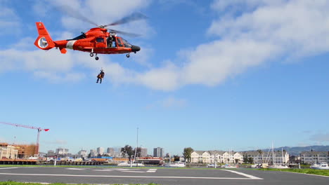 A-Us-Coast-Guard-Petty-Officer-And-His-Canine-Partner-Are-Lowered-By-Rope-From-A-Helicopter-To-The-Alameda-Coast-Guard-Base