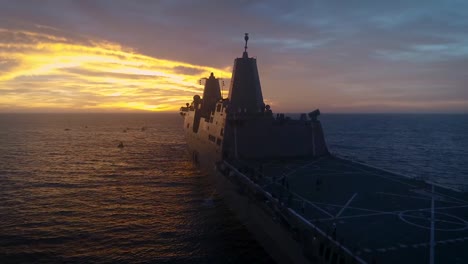Vista-Aérea-Drone-Footage-Showing-A-Large-Military-Boat-And-A-Test-Re-Entry-Spacecraft-At-Sea-Sunset-2019